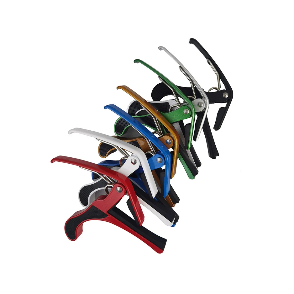 Muestra de capotrastes metálicos genéricos tipo pinza para guitarra en diferentes colores ordenados en diagonal.