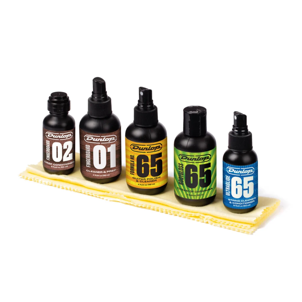 Cinco botellas de limpieza y acondicionamiento Jim Dunlop System 65 sobre paño de microfibra amarillo.